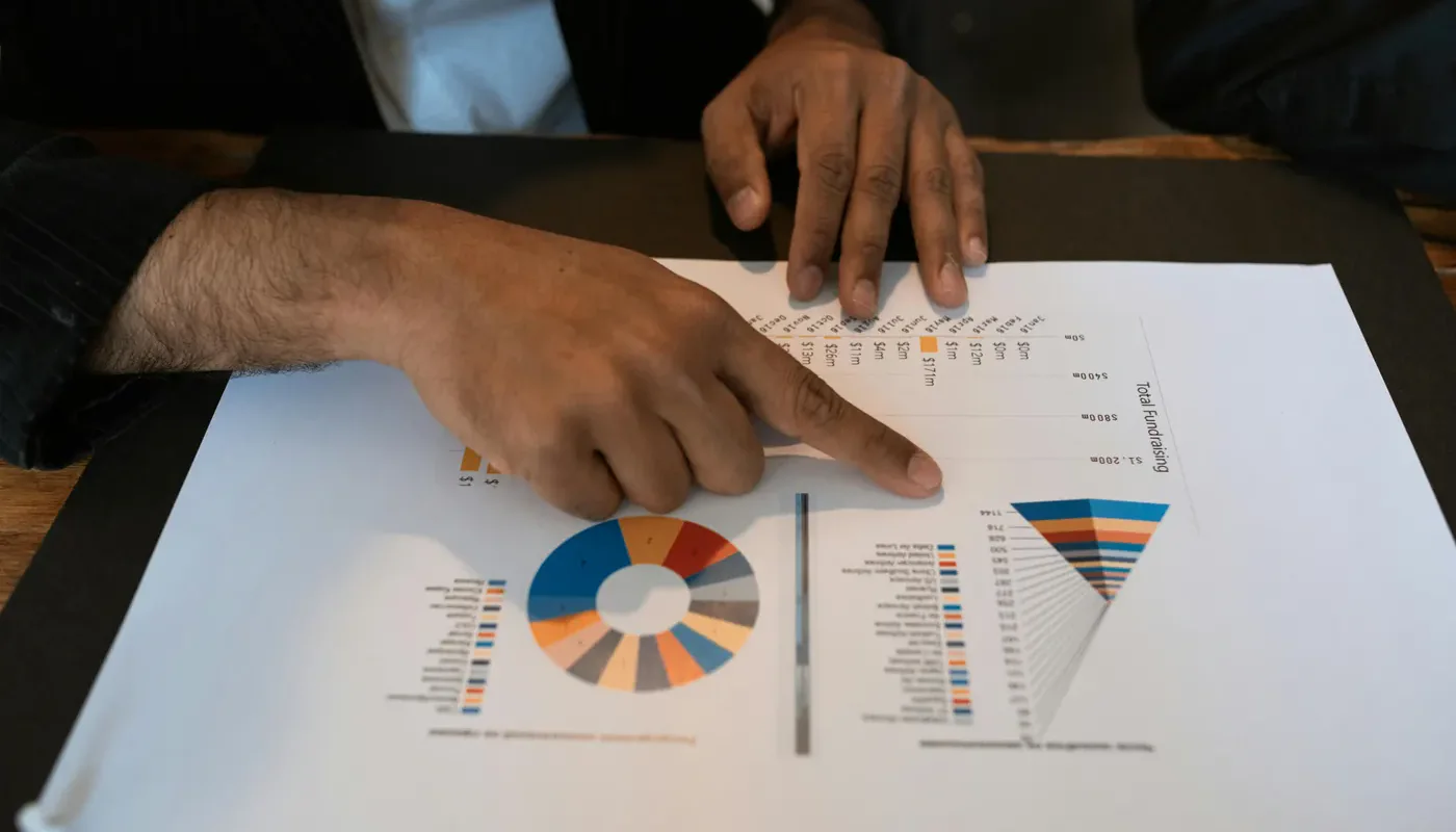 Hands reviewing printed business charts and graphs